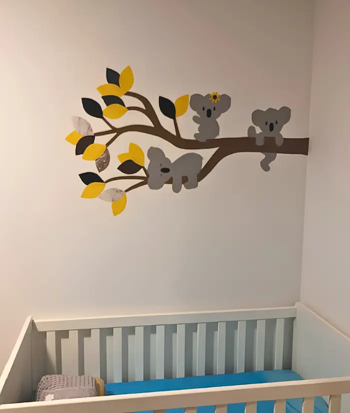Okergele babykamer met een koalatak behangsticker
